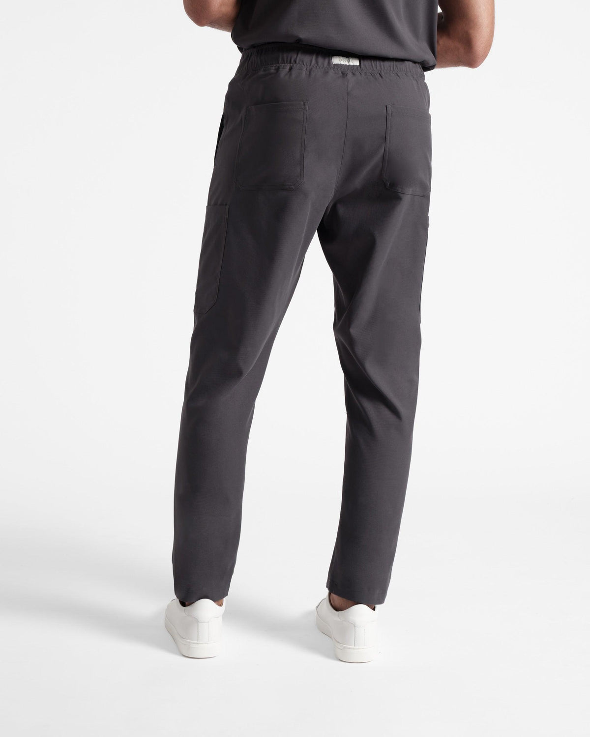 Back side view of dark grey cargo scrub pants with two back pockets.
