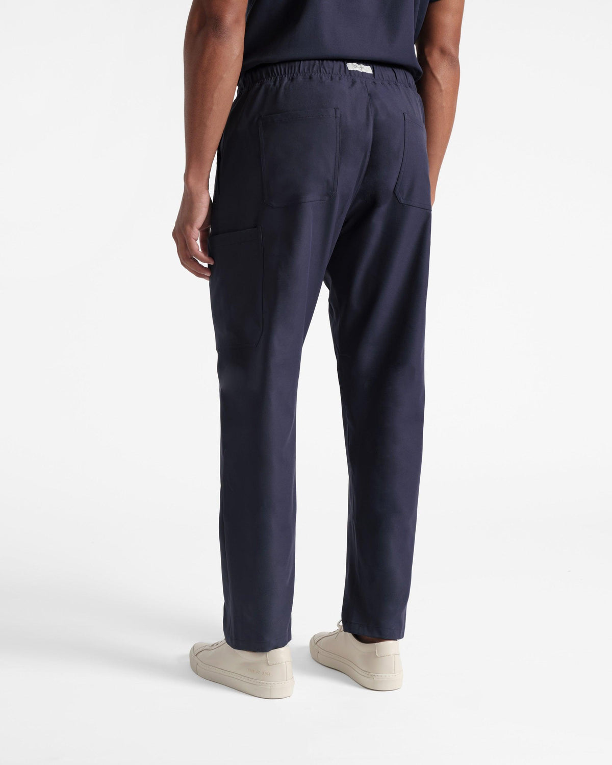 Back side view of man in navy cargo scrub pants with two back pockets.