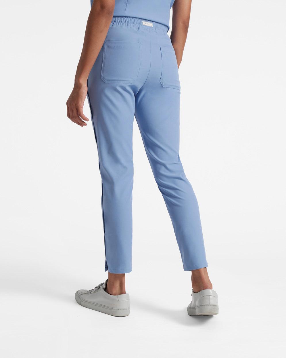 Back side view of woman wearing light blue straight leg scrub pants with two back pockets.