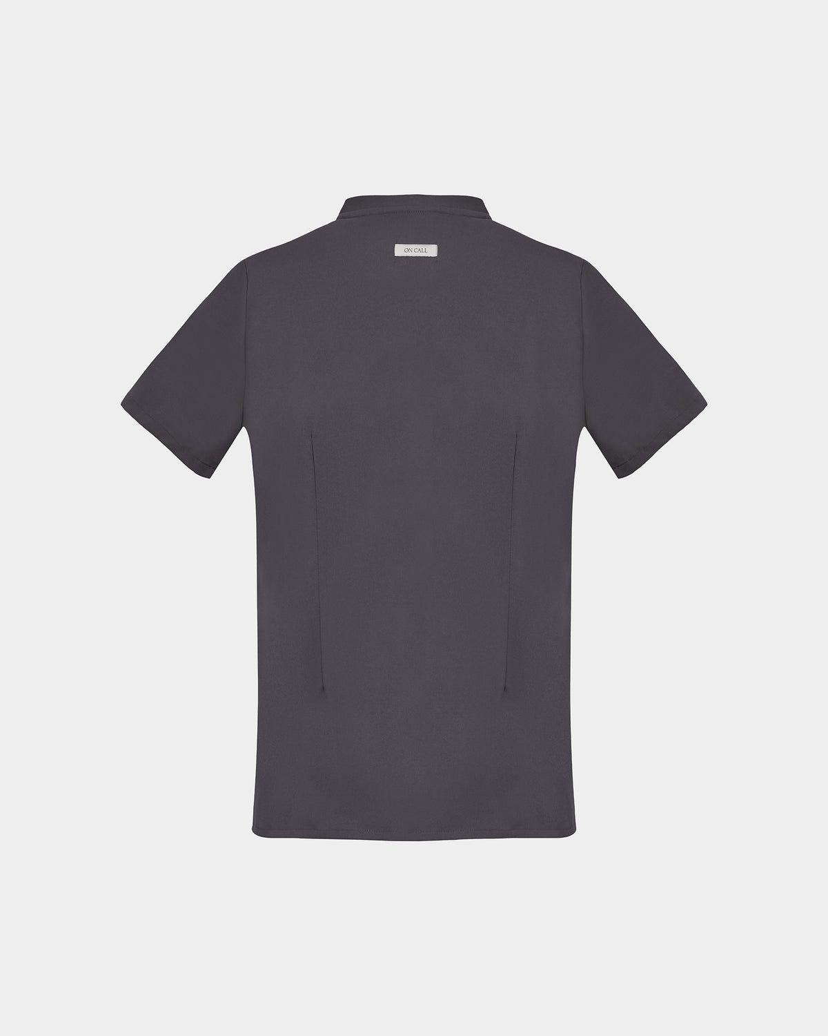 A dark grey short-sleeve scrub shirt shown from the back, featuring two back darts and a logo label, displayed on a light gray background.