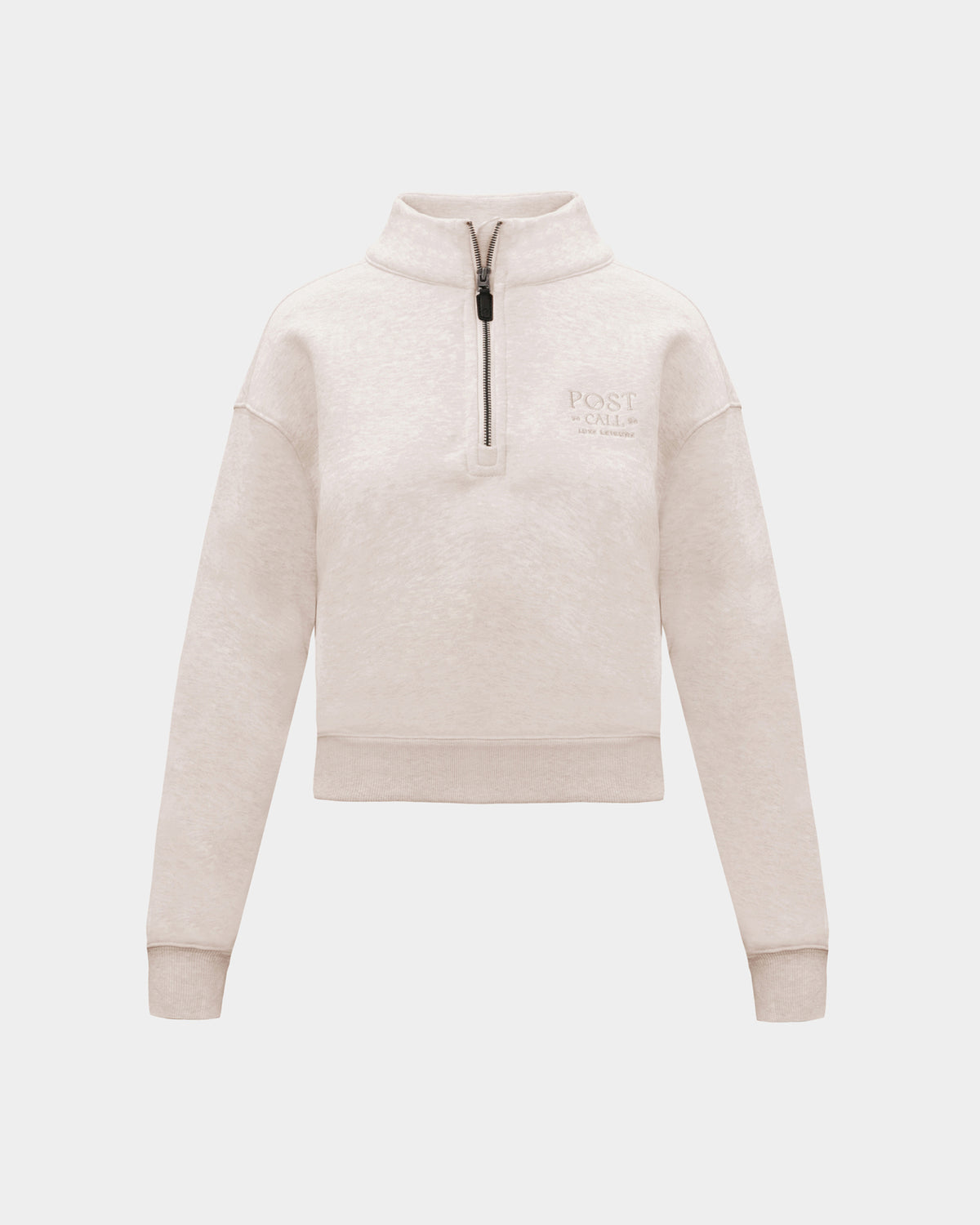 A heather beige half-zip sweatshirt with small tonal embroidered logo on the left chest, displayed on a clean light gray background.