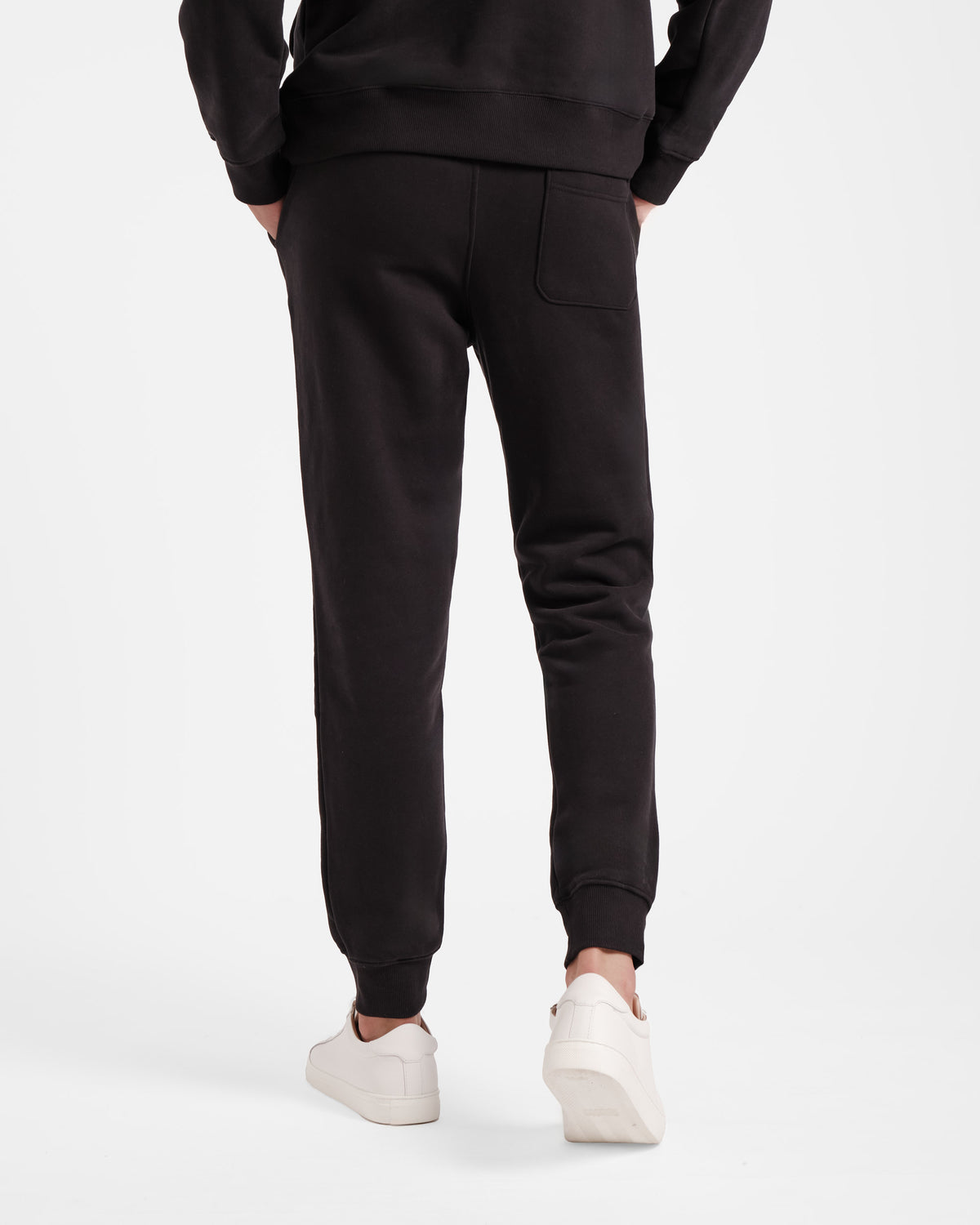 Back side view of man in black jogger sweatpants with back pocket.
