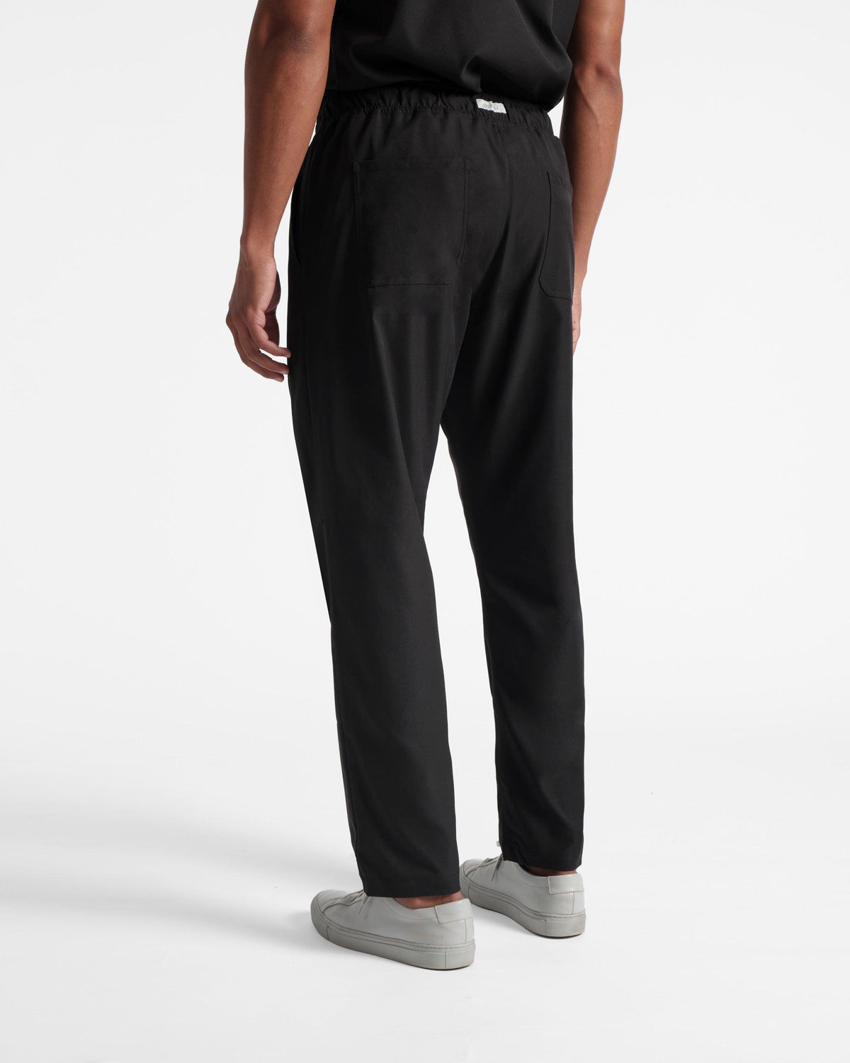 Back side view of black straight leg scrub pants with two back pockets.