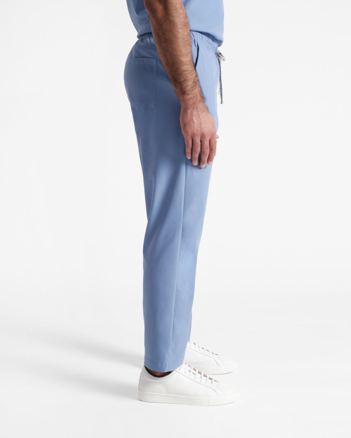 Side view of man in light blue straight leg scrub pants.