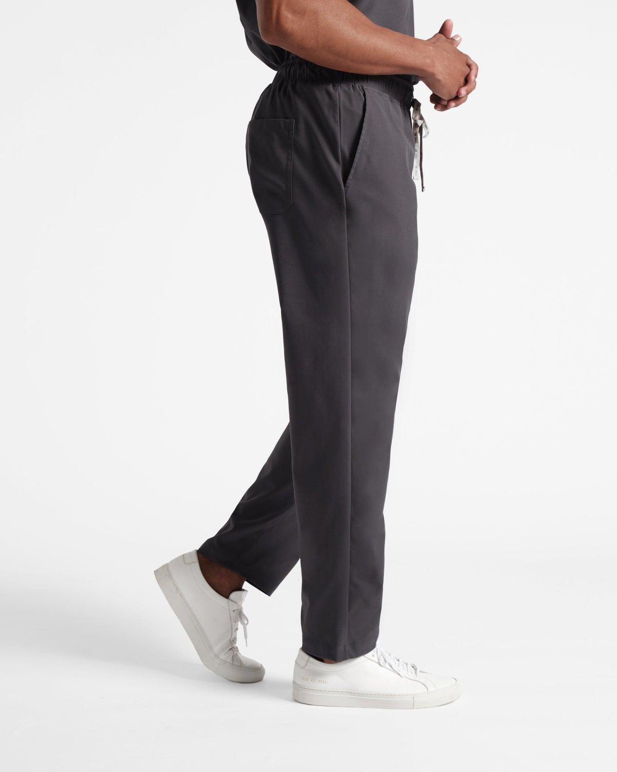 Side view of man in dark grey straight leg classic scrub pants.
