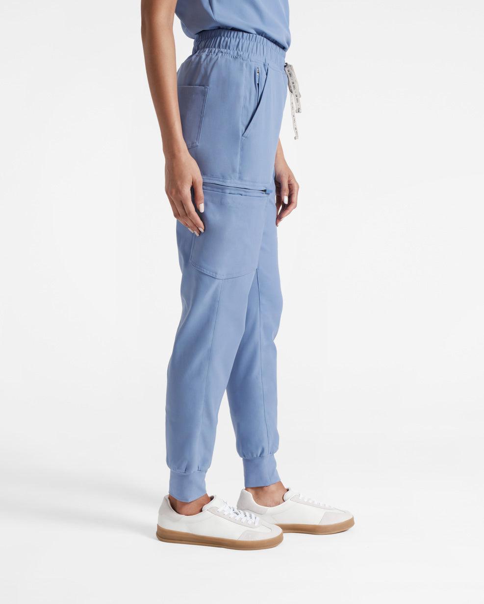 Side view of woman from the waist down wearing light blue cargo jogger scrub pants.