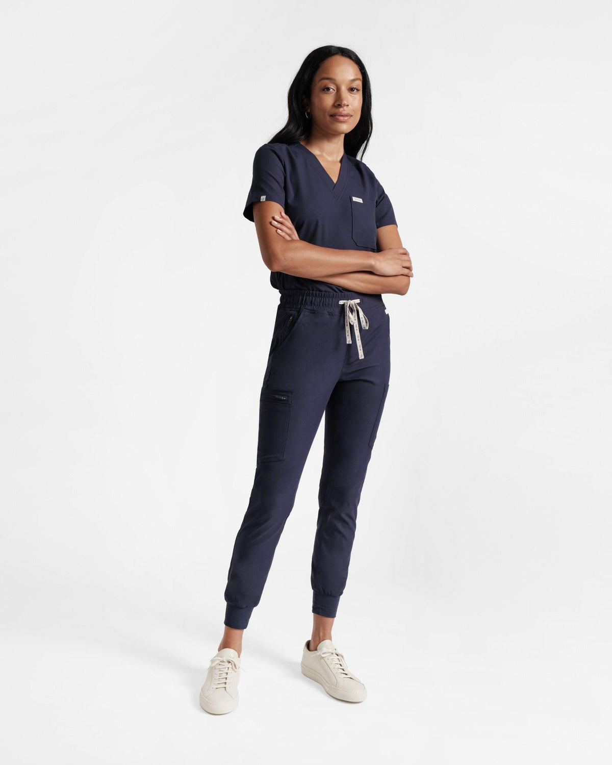 Woman in a matching scrub shirt and cargo jogger scrub pants, both in navy.
