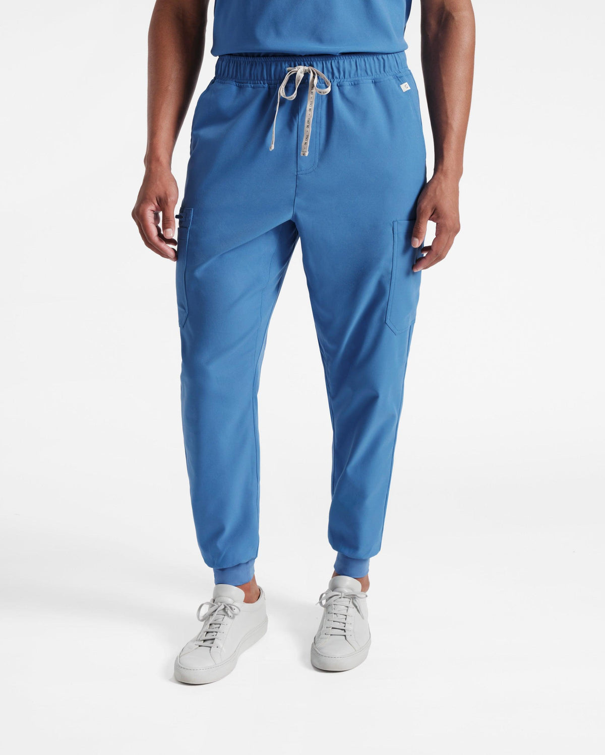 Man from the waist down in bright blue jogger cargo scrub pants.