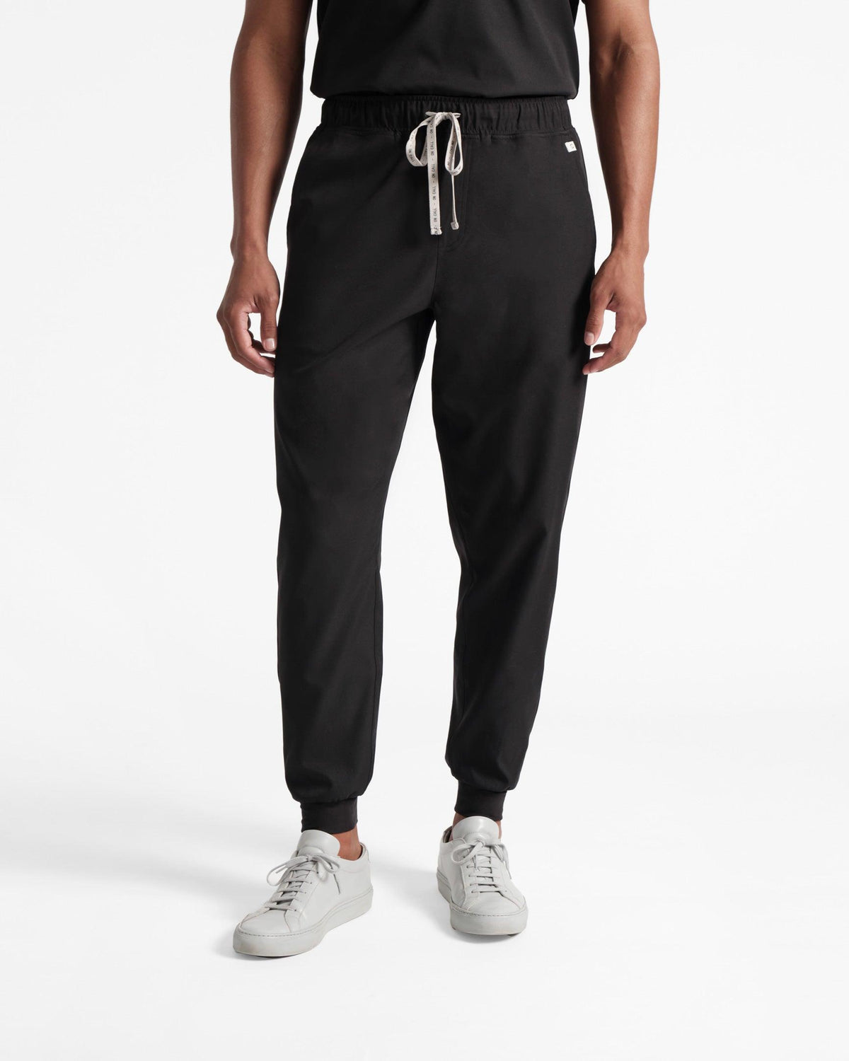 Model wearing men's jogger scrub pants in black.