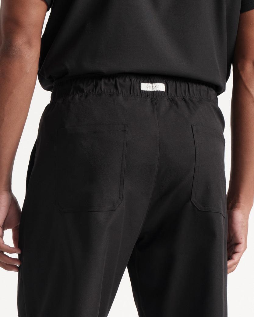 Close up view of back pockets and waistband with branded On Call fabric label in the middle of it.