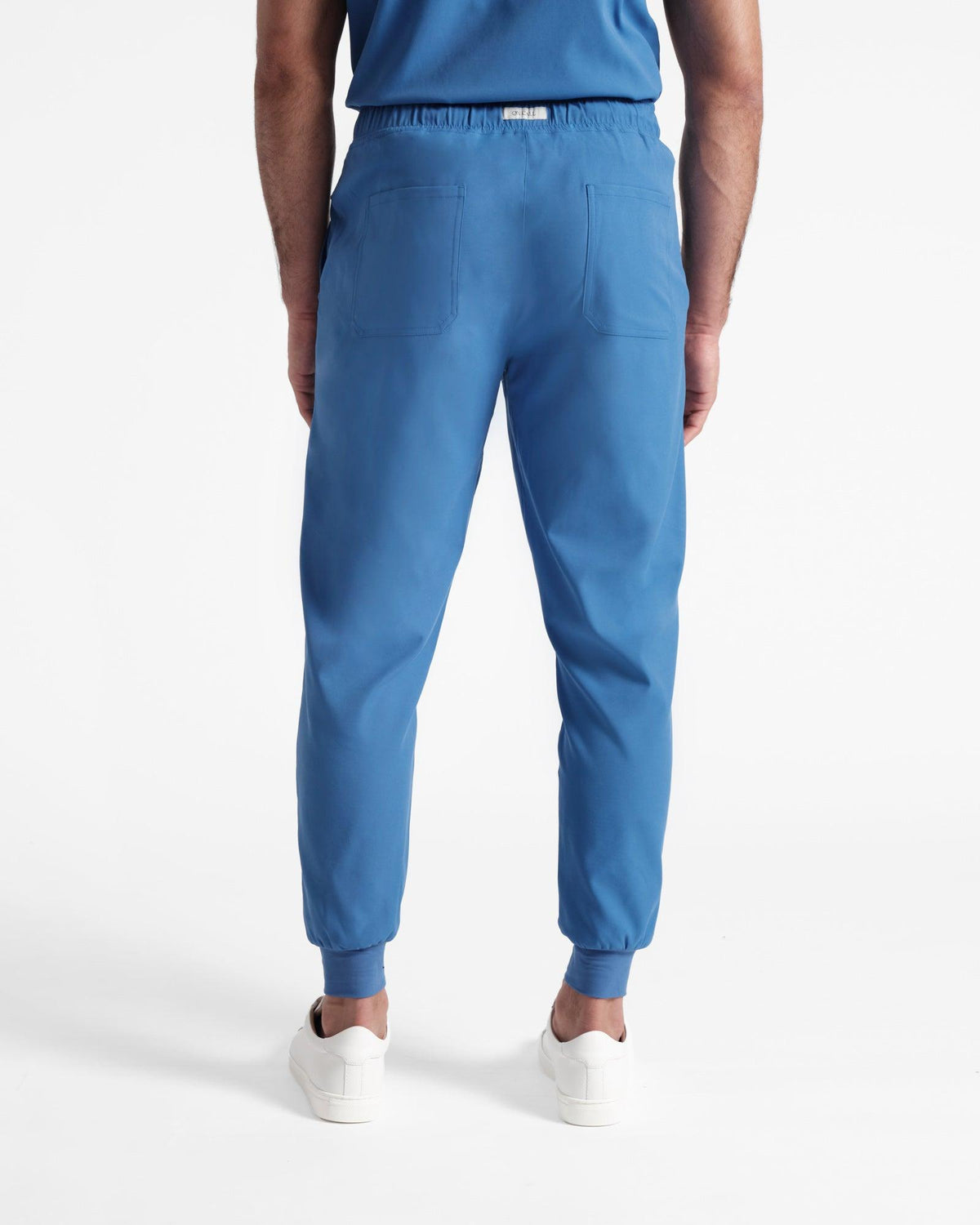Back side view of man in bright blue jogger scrub pants with two back pockets.