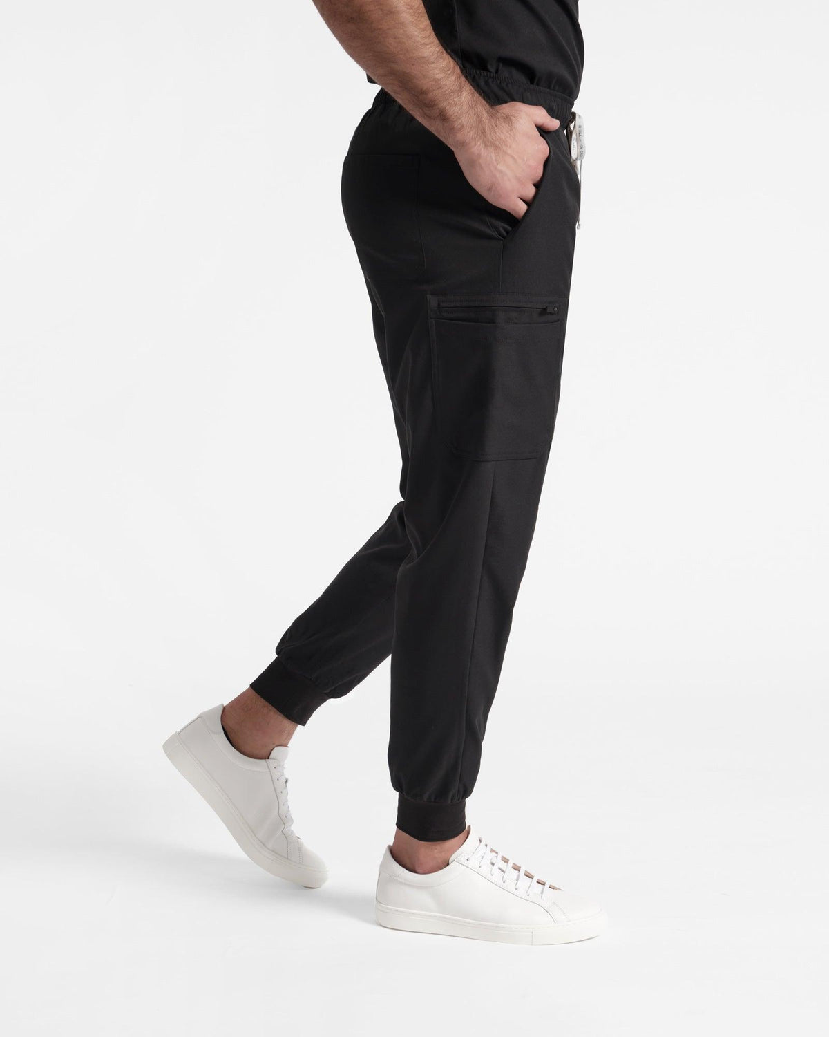 Side view of men's black cargo jogger scrub pants with elasticated cuffs.