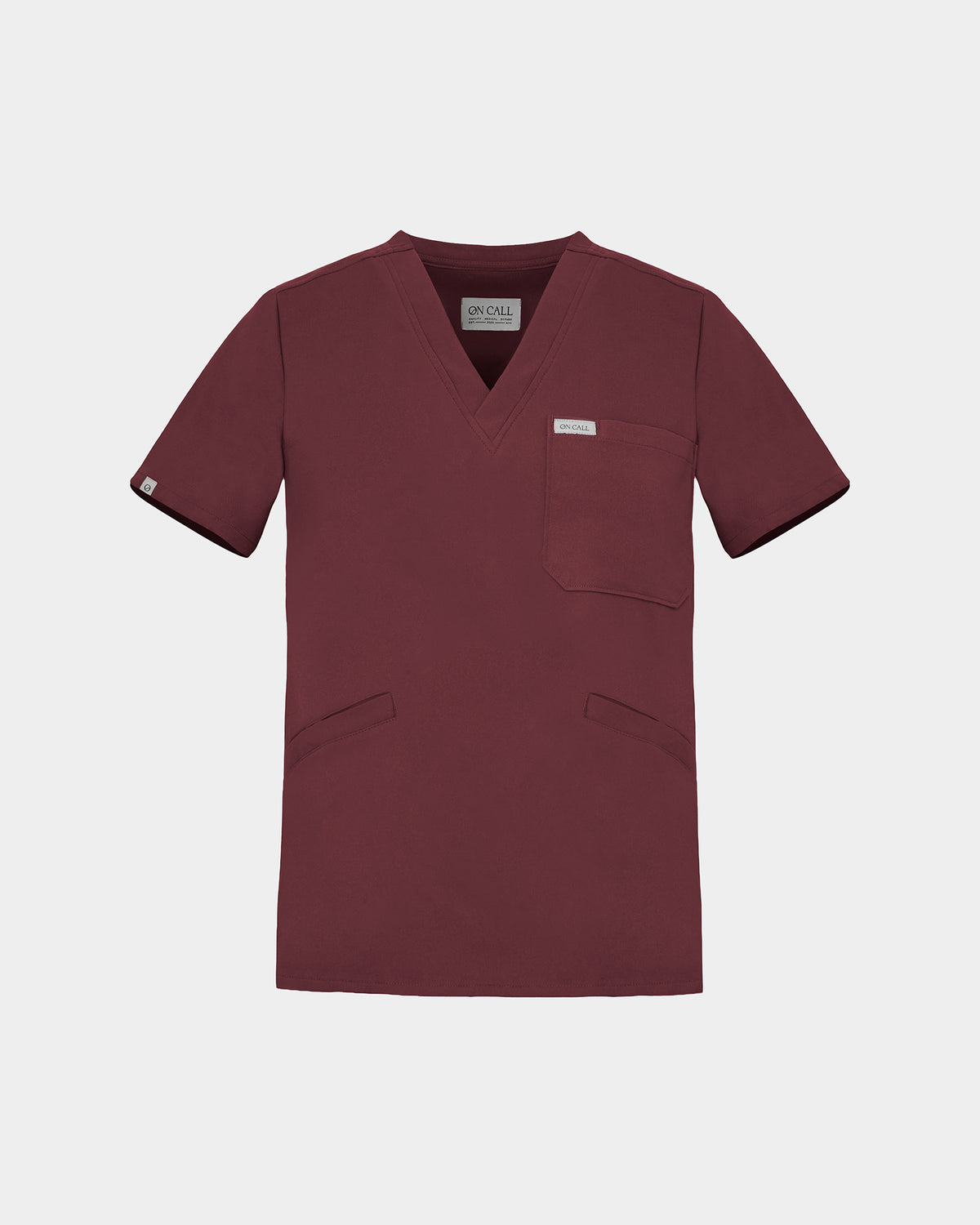 A v-neck scrub shirt in a dark heme red color, featuring a chest pocket and two additional lower pockets on the front.