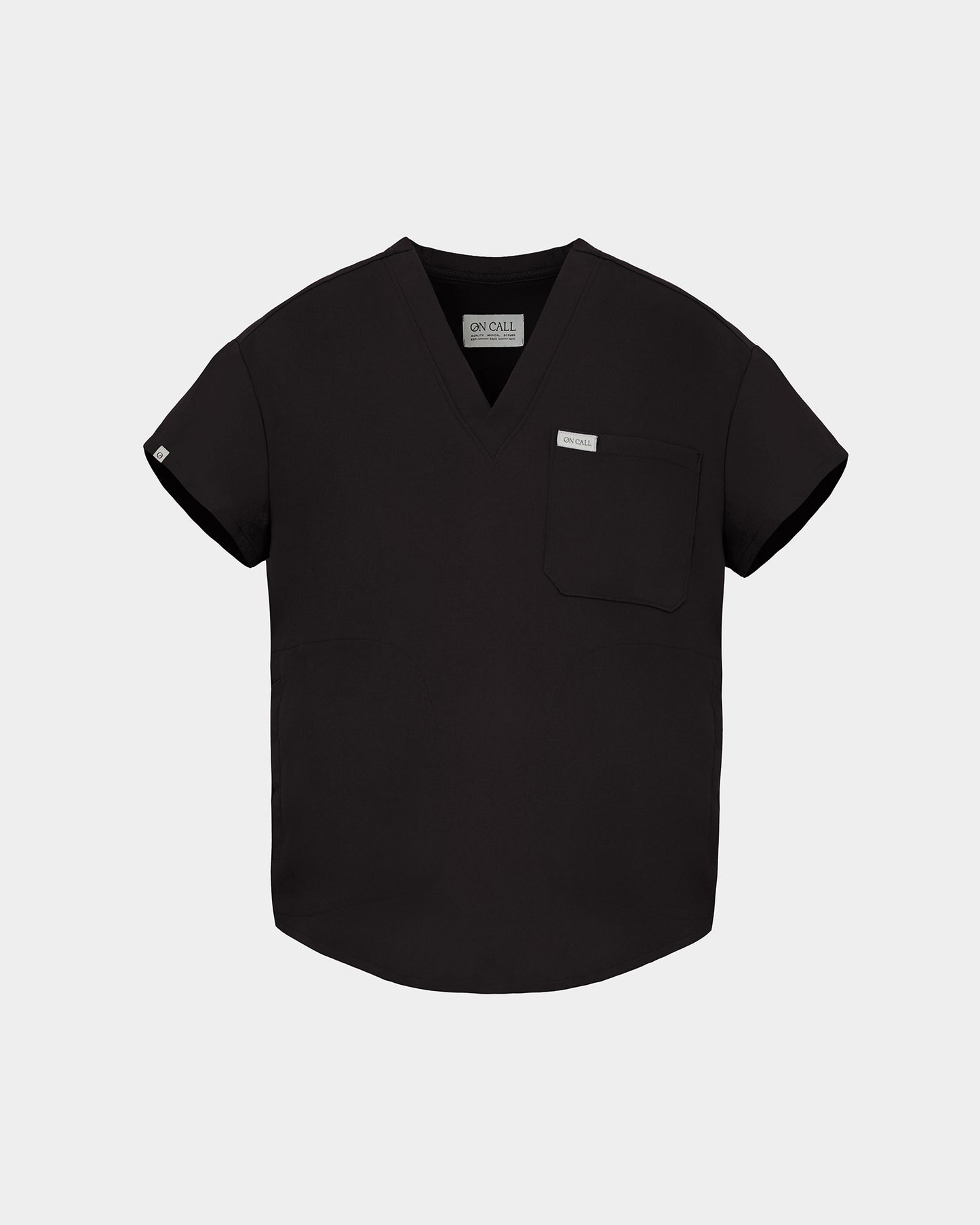 A black short-sleeve V-neck scrub top with a chest pocket and a small white brand tag, displayed on a light gray background.