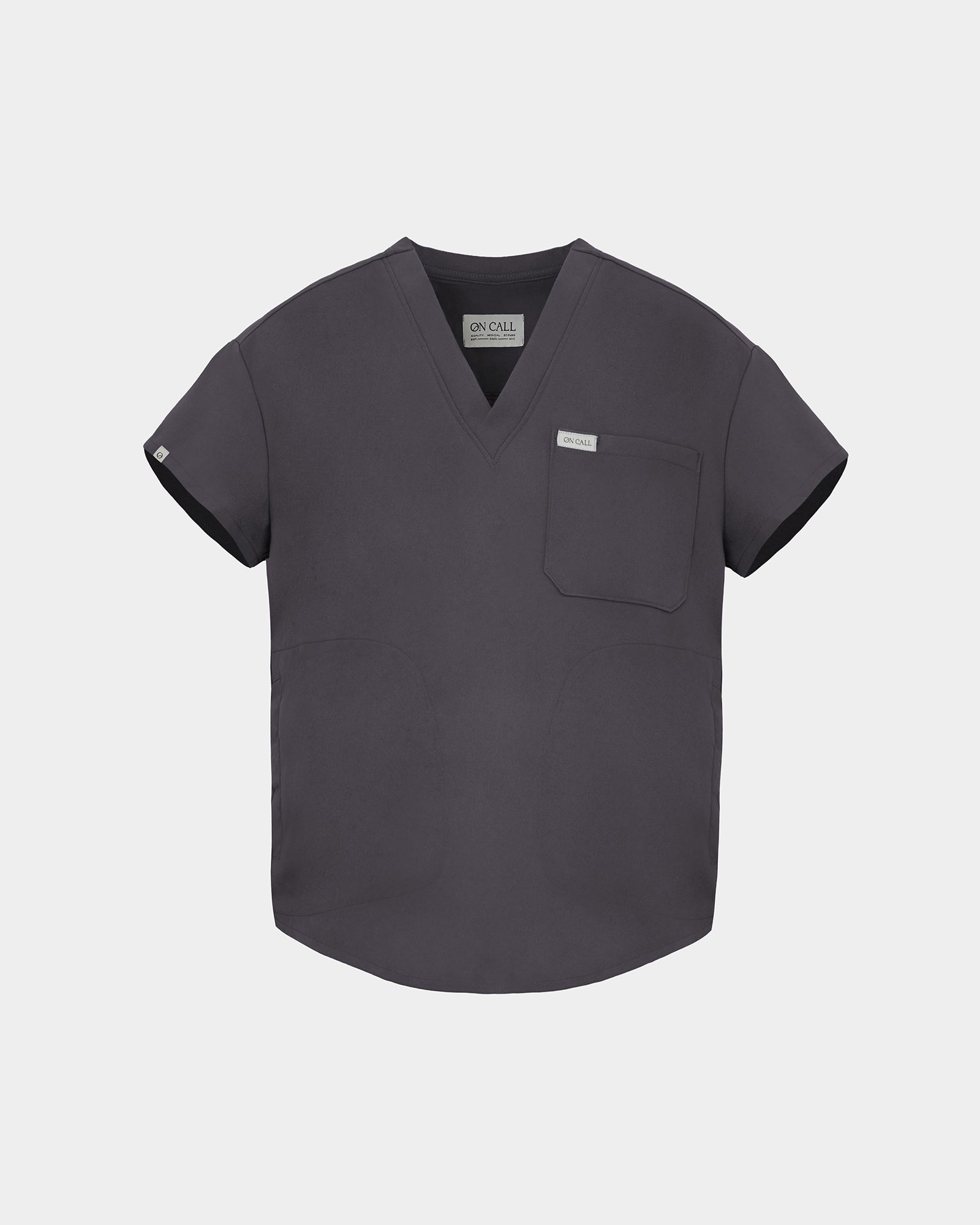 A dark gray V-neck scrub top with short sleeves, a chest pocket, and a small white brand tag on the left chest, displayed against a light gray background.