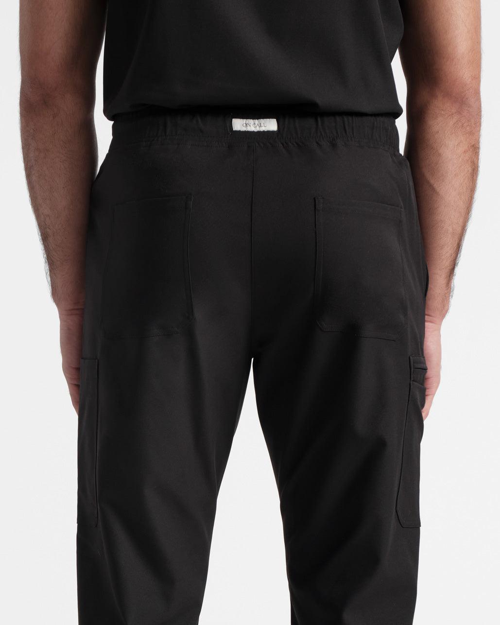 Close up view of back pockets and waistband on black cargo scrub pants.