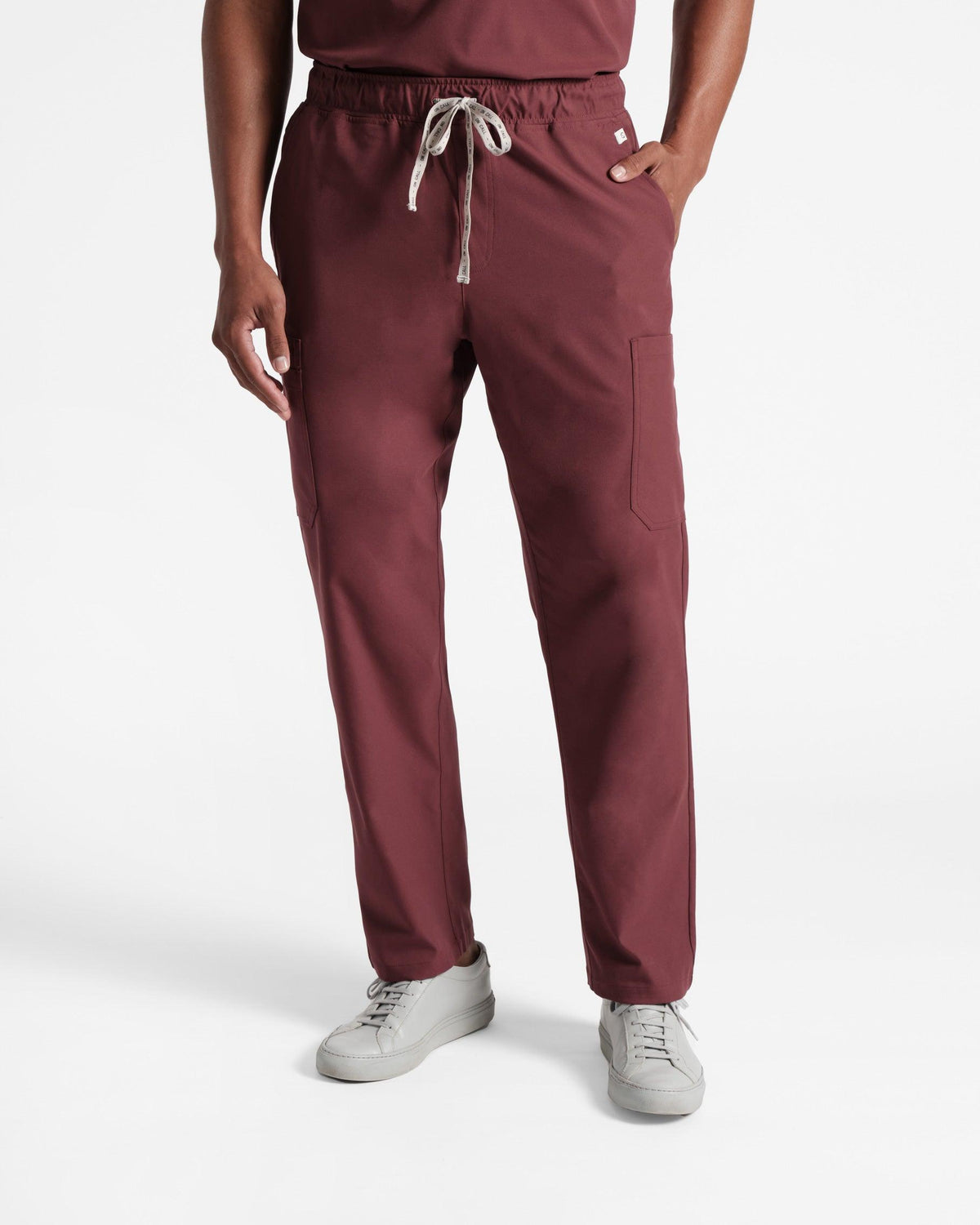 Man in deep red cargo scrub pants with hand in pocket.