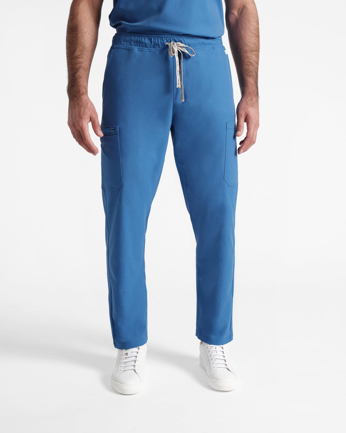 Man in bright blue cargo scrub pants with a branded waistband tie.