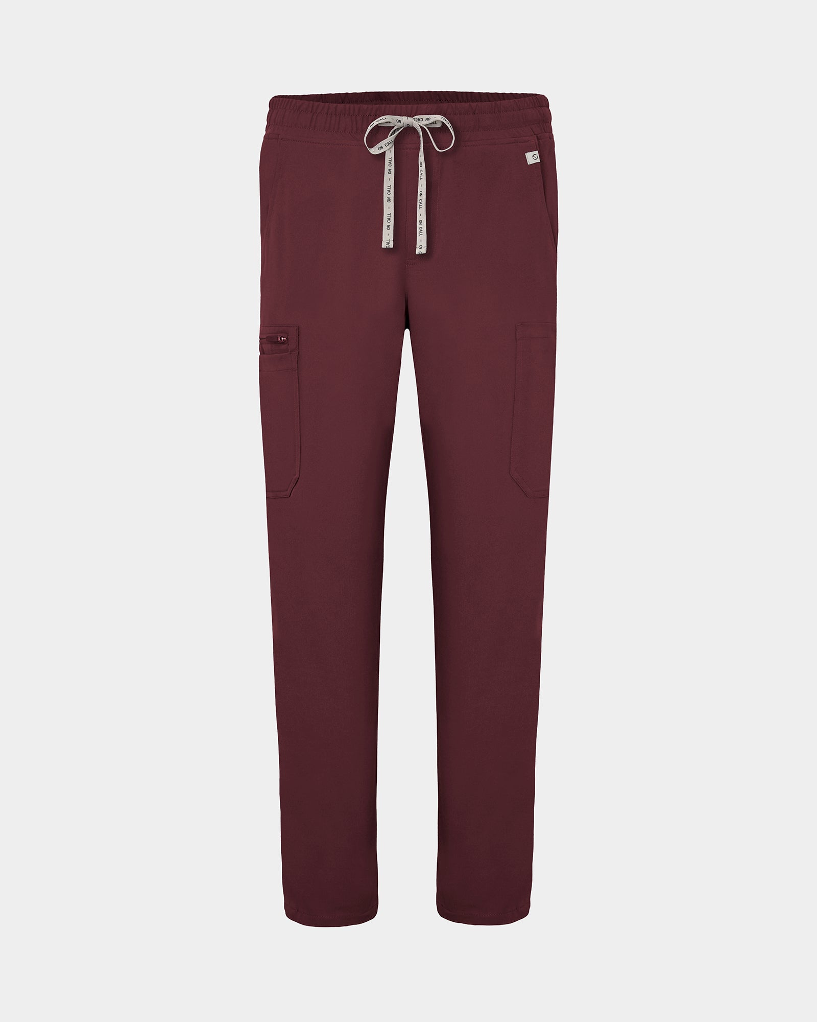 Heme red scrub pants with cargo pockets, a logo drawstring tie, set against a solid light grey background.