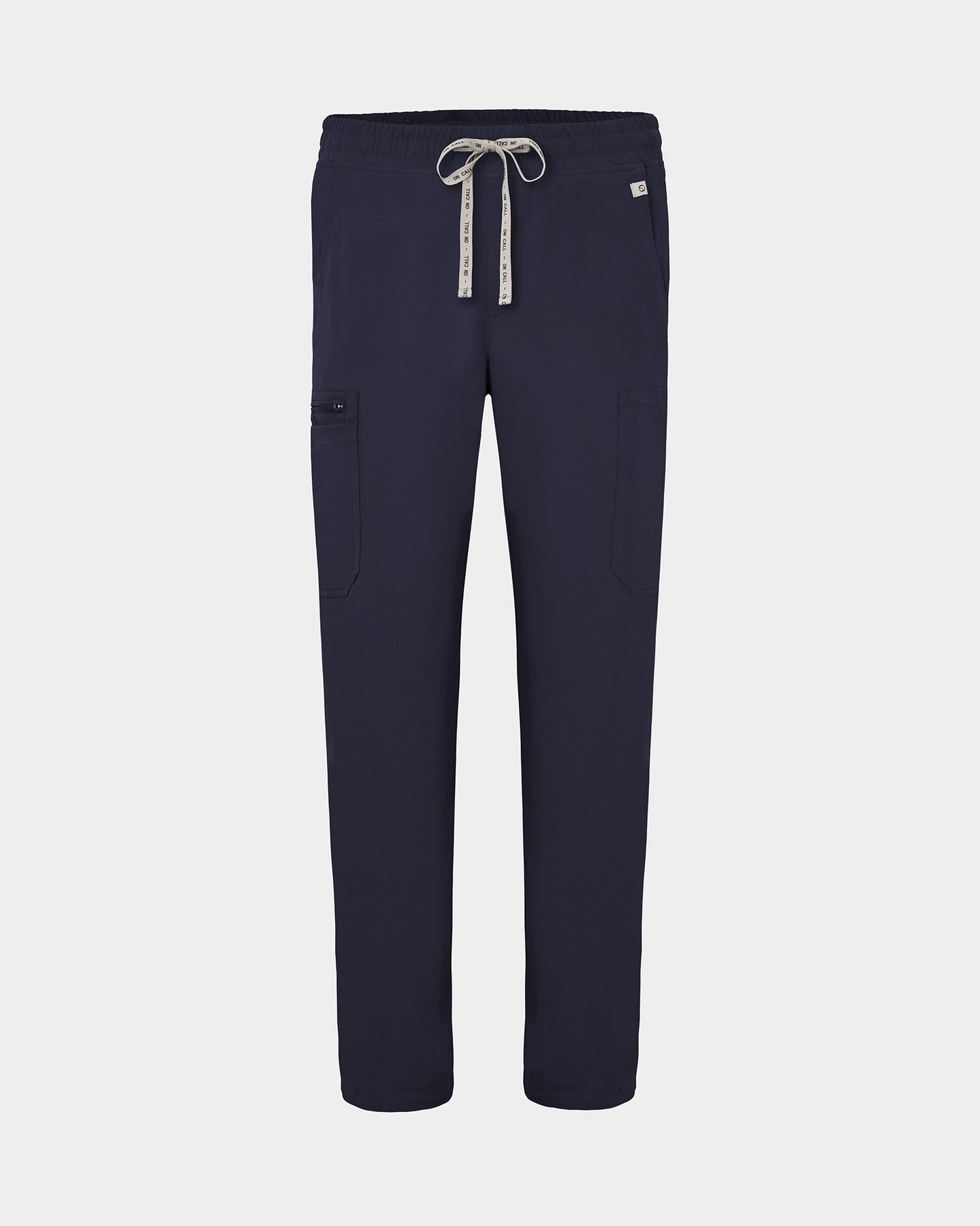 Navy scrub pants with cargo pockets, a logo drawstring tie, set against a solid light grey background.