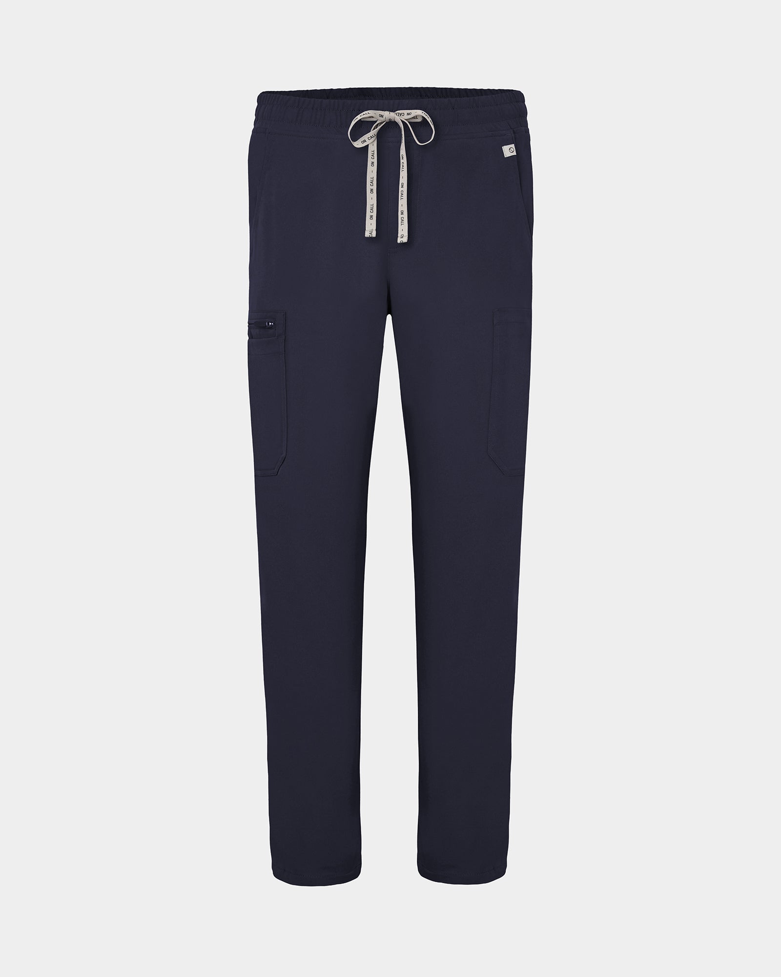 Navy scrub pants with cargo pockets, a logo drawstring tie, set against a solid light grey background.