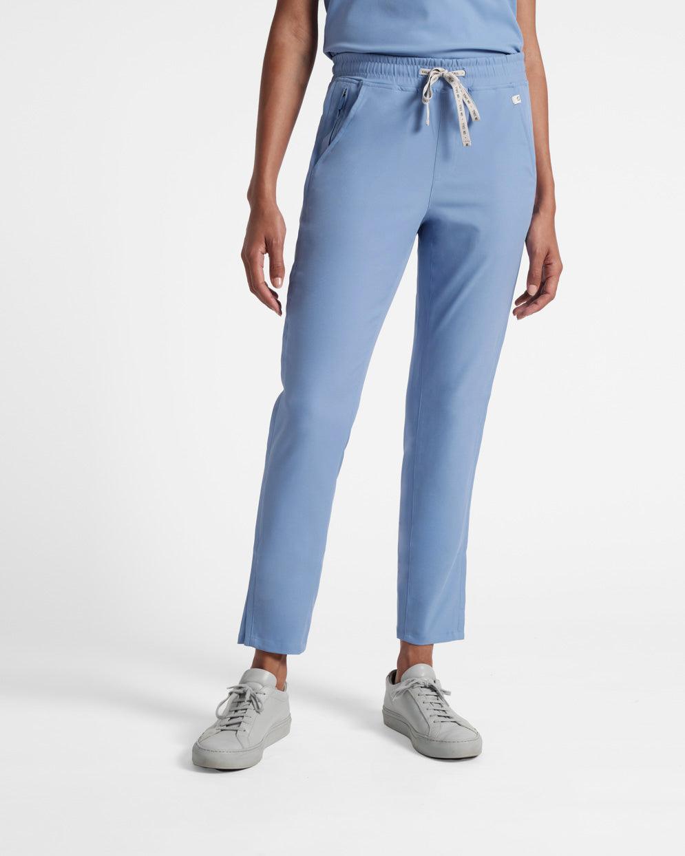 Waist down view of woman wearing light blue straight leg scrub pants.