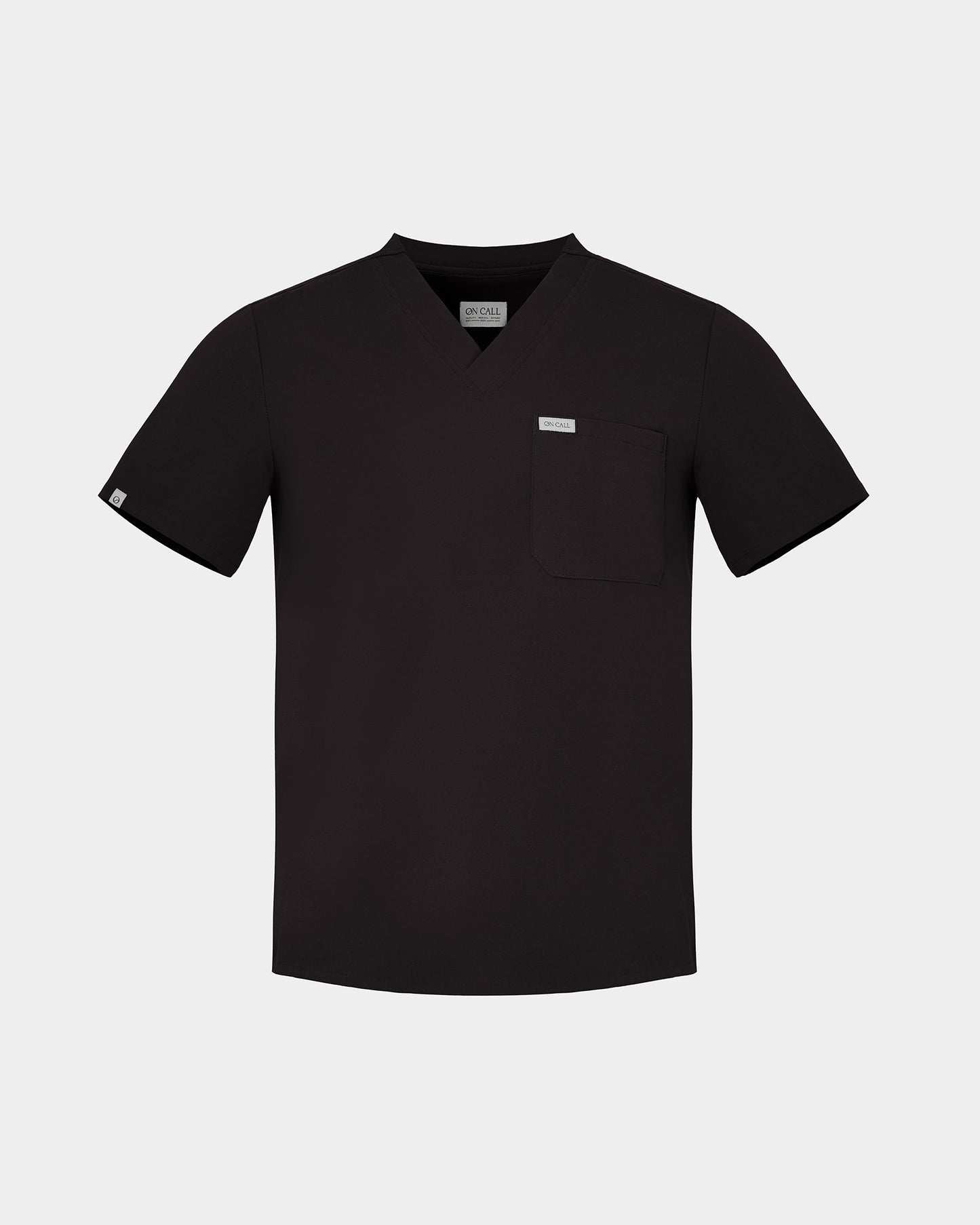 A black short-sleeve scrub top with a V-neck, a chest pocket, and a small white rectangular label on the pocket, displayed against a light gray background.