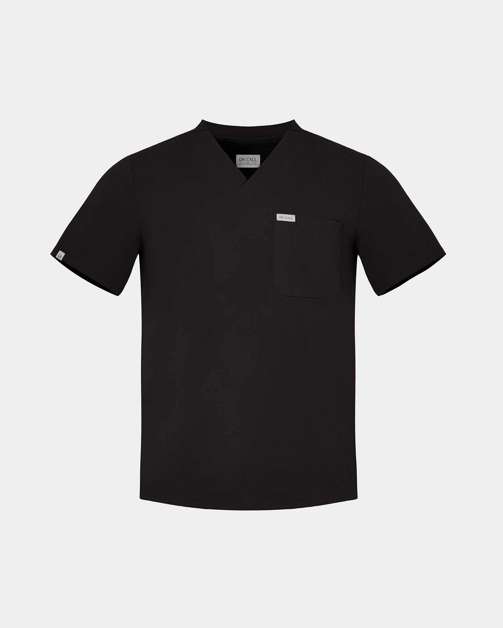 A black short-sleeve scrub top with a V-neck, a chest pocket, and a small white rectangular label on the pocket, displayed against a light gray background.