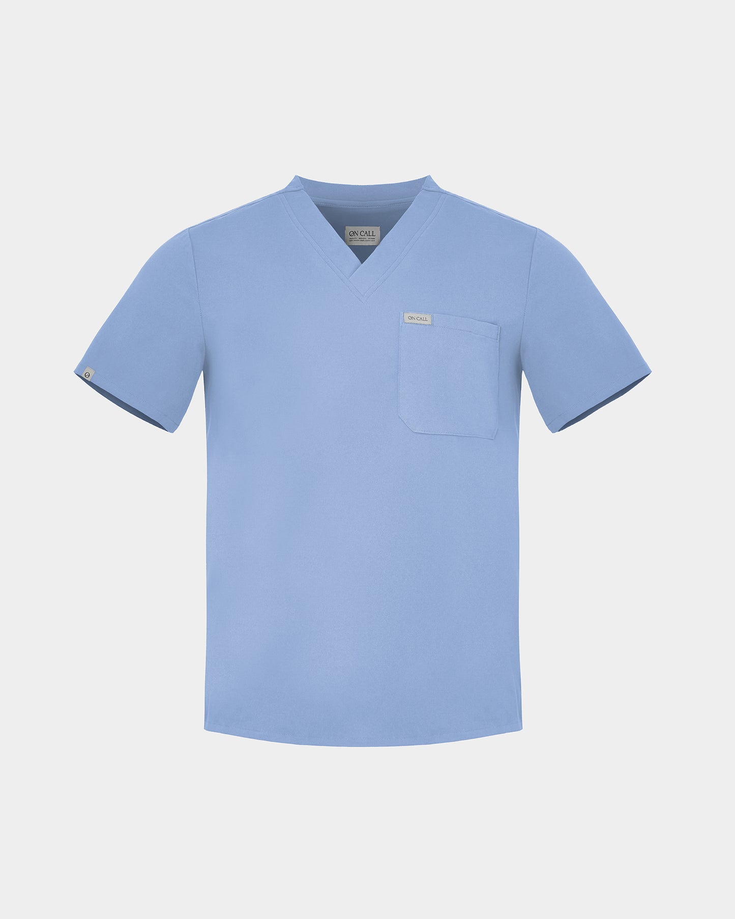 A light blue V-neck scrub top with a single chest pocket, displayed on a neutral light gray background.