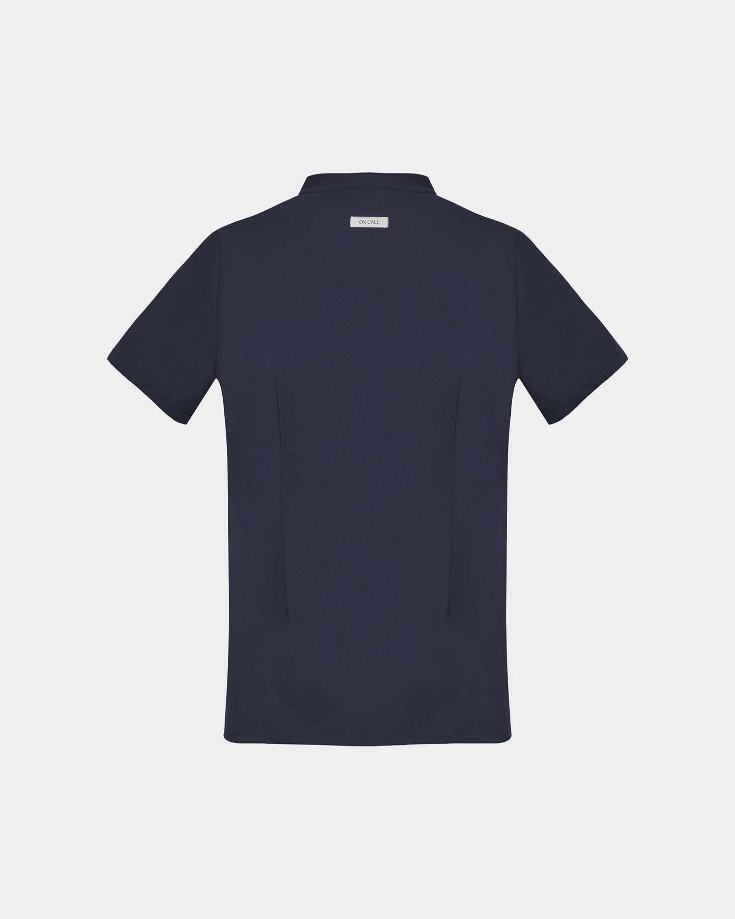 A dark navy blue short-sleeve scrub shirt shown from the back, featuring two darts, centered on a light gray background.