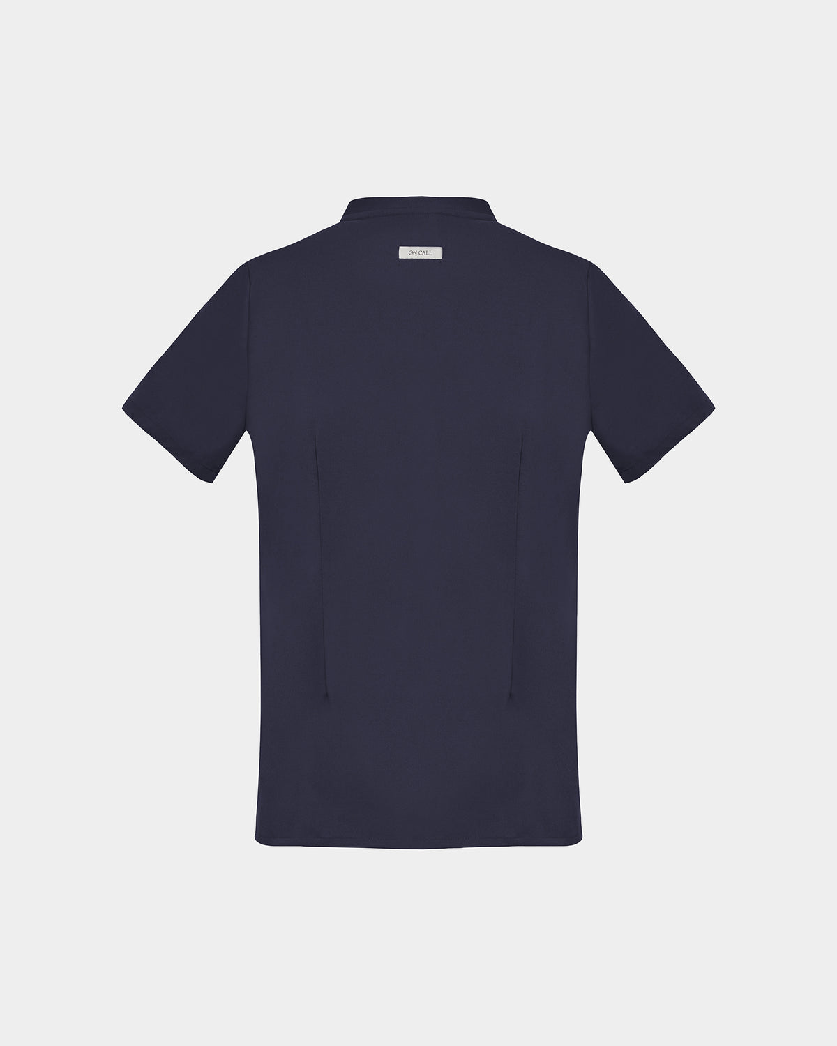 A dark navy blue short-sleeve scrub shirt shown from the back, featuring two darts, centered on a light gray background.