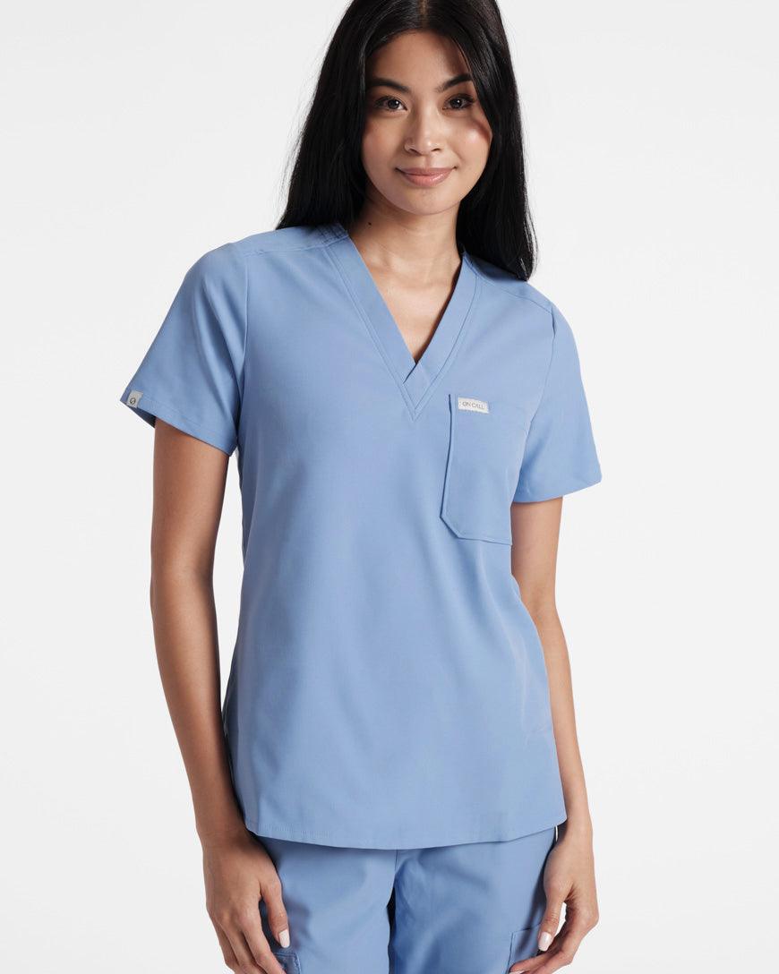 Woman in light blue v-neck scrub shirt with a chest pocket.
