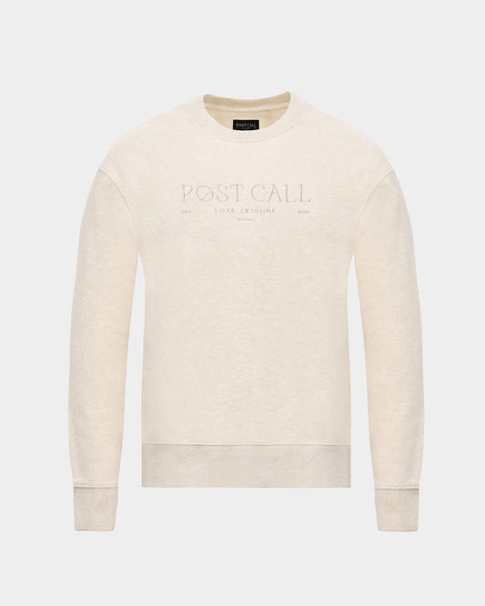 A heather beige crewneck sweatshirt with a tonal embroidered 'POST CALL' logo on the center of the chest, displayed on a clean light gray background.