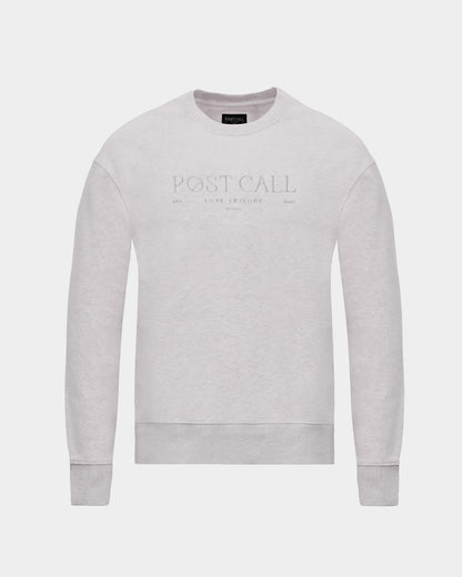 A light gray crewneck sweatshirt with 'POST CALL' embroidered in a subtle, tonal thread across the chest, displayed on a clean light gray background.