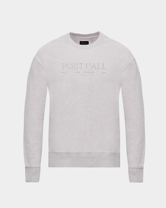 A light gray crewneck sweatshirt with 'POST CALL' embroidered in a subtle, tonal thread across the chest, displayed on a clean light gray background.