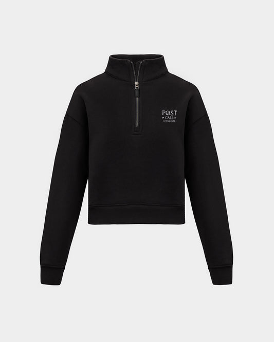 A black half-zip sweatshirt with a small white 'POST CALL' logo on the left chest, displayed on a clean light gray background.