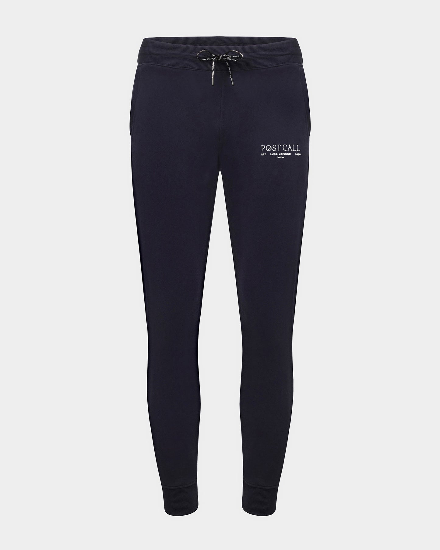Navy jogger lounge pants with ankle cuffs, a logo drawstring, and a contrast embroidered 'POST CALL' logo in white on the left thigh.