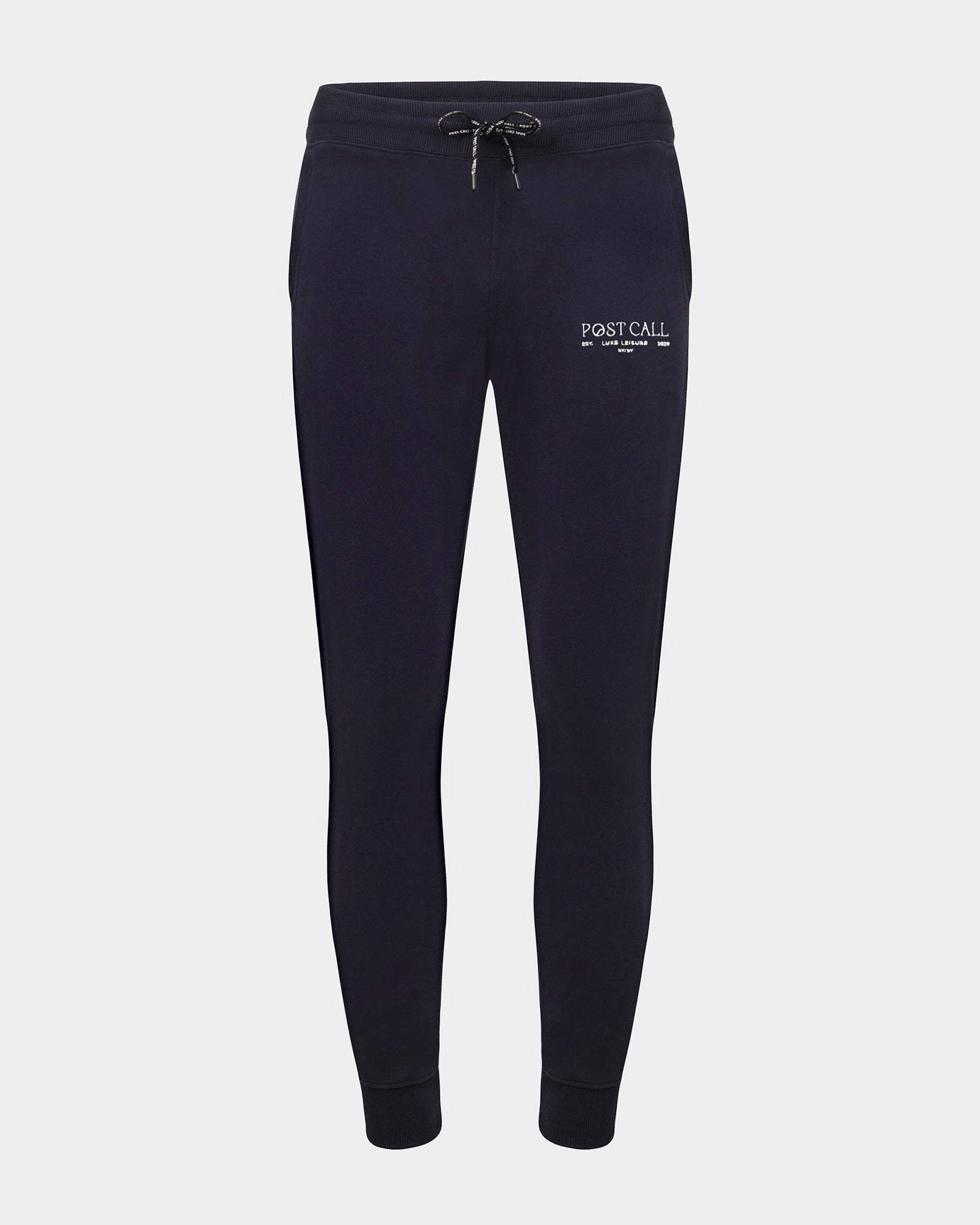 Navy jogger lounge pants with ankle cuffs, a logo drawstring, and a contrast embroidered 'POST CALL' logo in white on the left thigh.