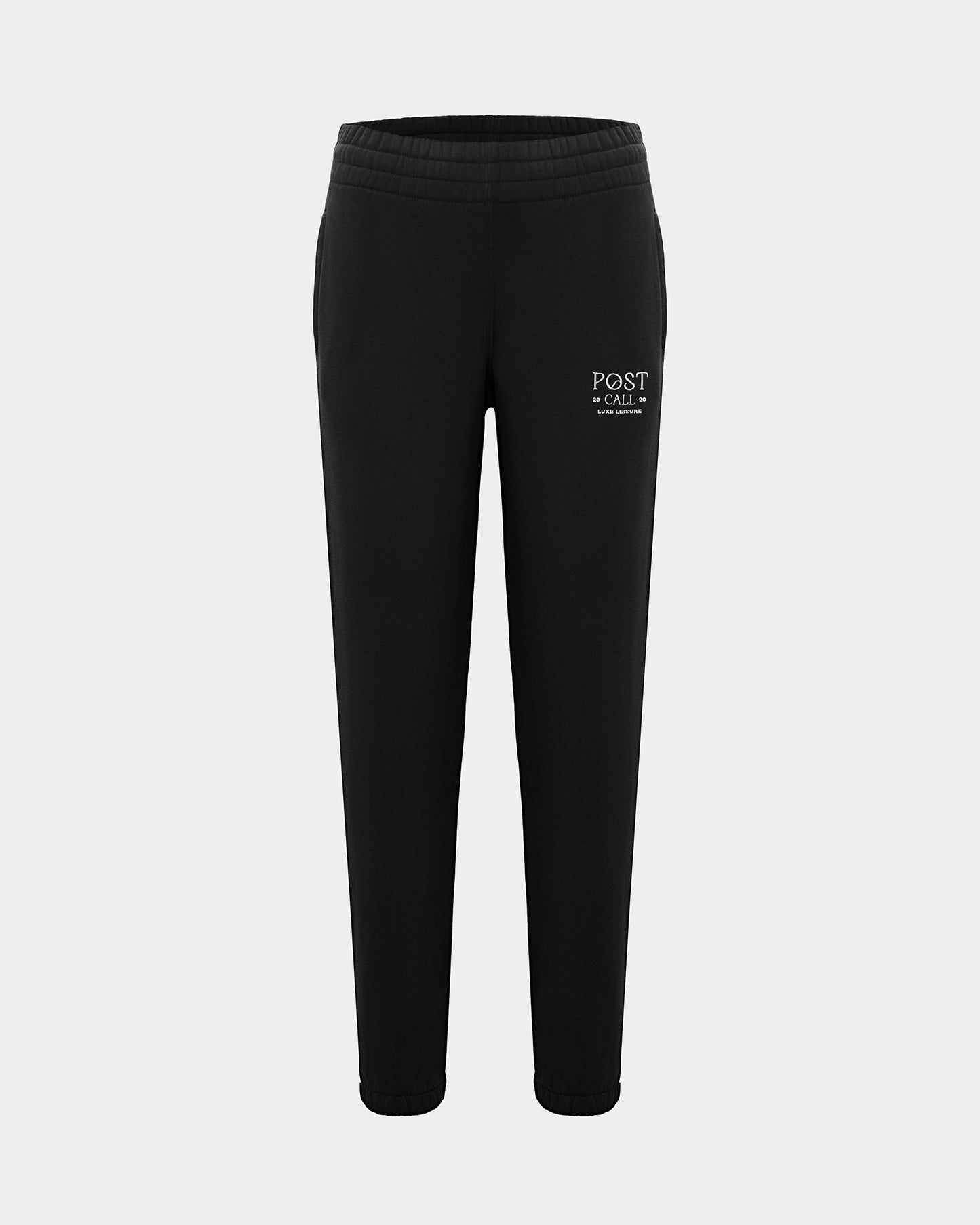 Black lounge pants with a thick elasticated waistband, hidden drawstring, elasticated ankle cuffs, and contrast logo embroidery on the left thigh.