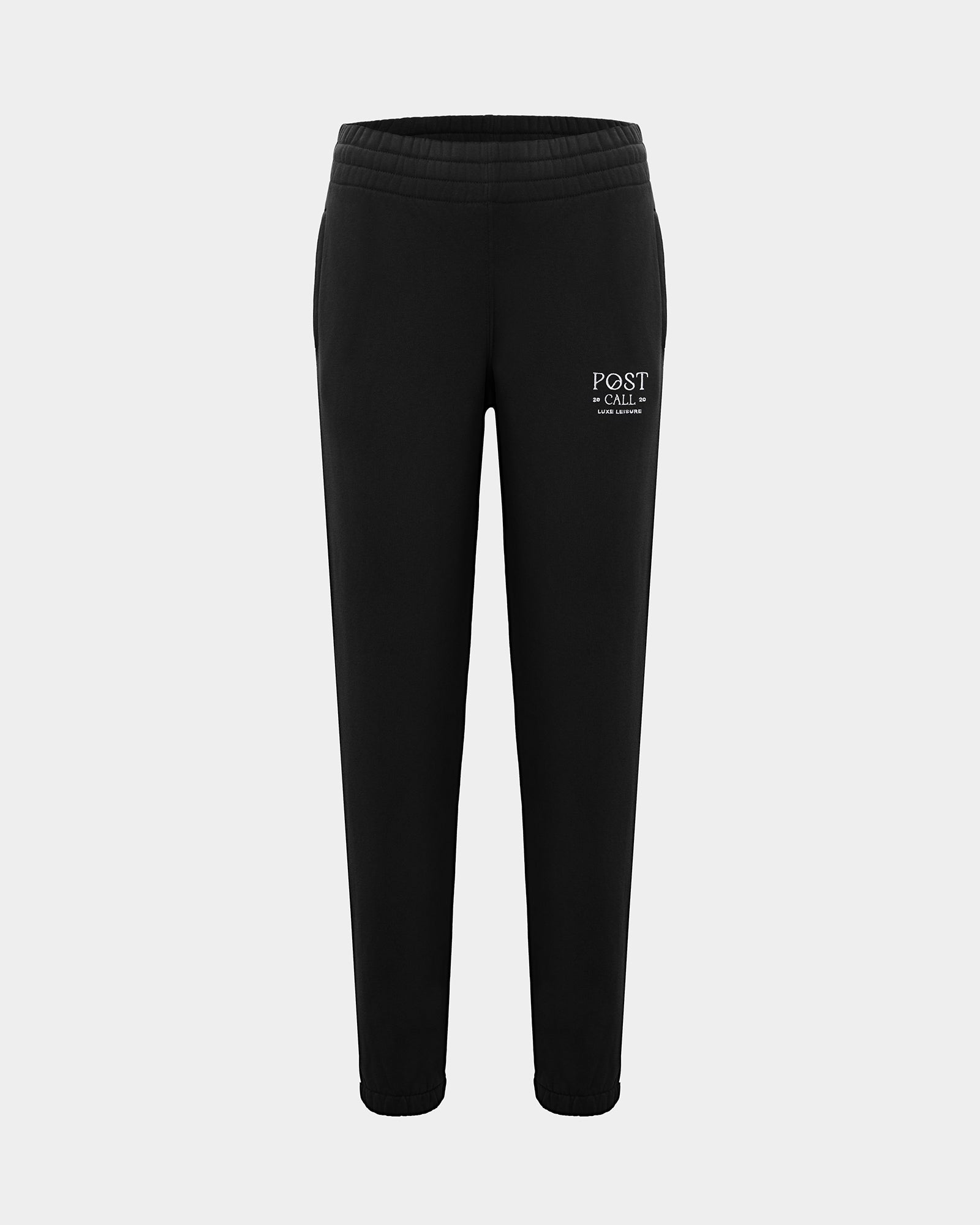 Black lounge pants with a thick elasticated waistband, hidden drawstring, elasticated ankle cuffs, and contrast logo embroidery on the left thigh.