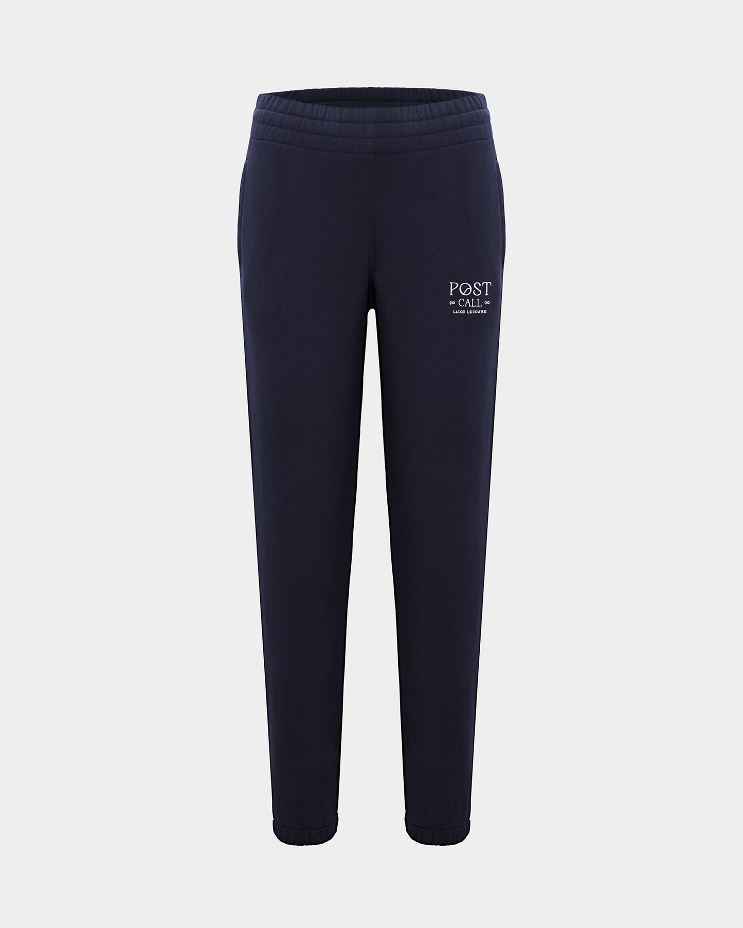 A pair of navy blue sweatpants with a white 'POST CALL' logo embroidered on the left thigh, shown against a light gray background.