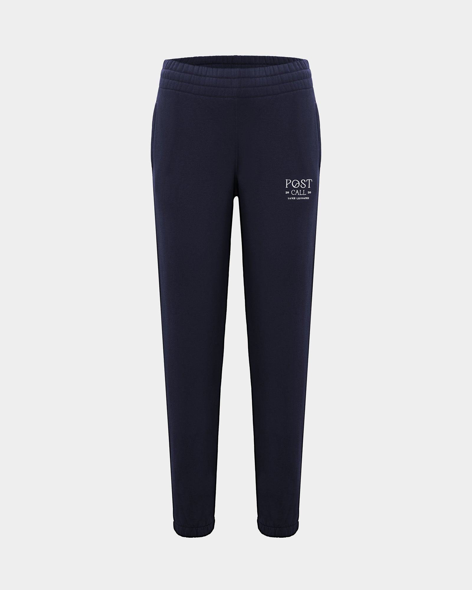 A pair of navy blue sweatpants with a white 'POST CALL' logo embroidered on the left thigh, shown against a light gray background.