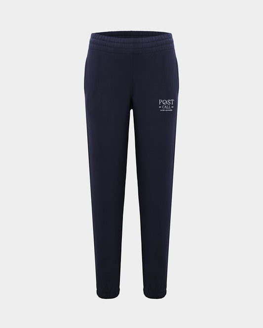 A pair of navy blue sweatpants with a white 'POST CALL' logo embroidered on the left thigh, shown against a light gray background.