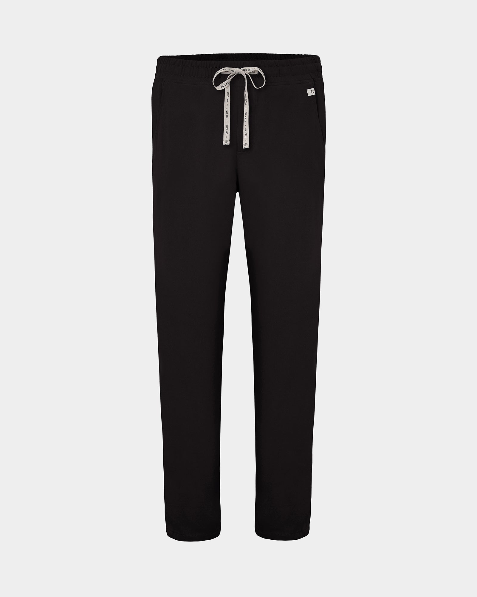 Black straight leg scrub pants with a white logo drawstring and a small white logo on the left hip, shown against a light gray background.