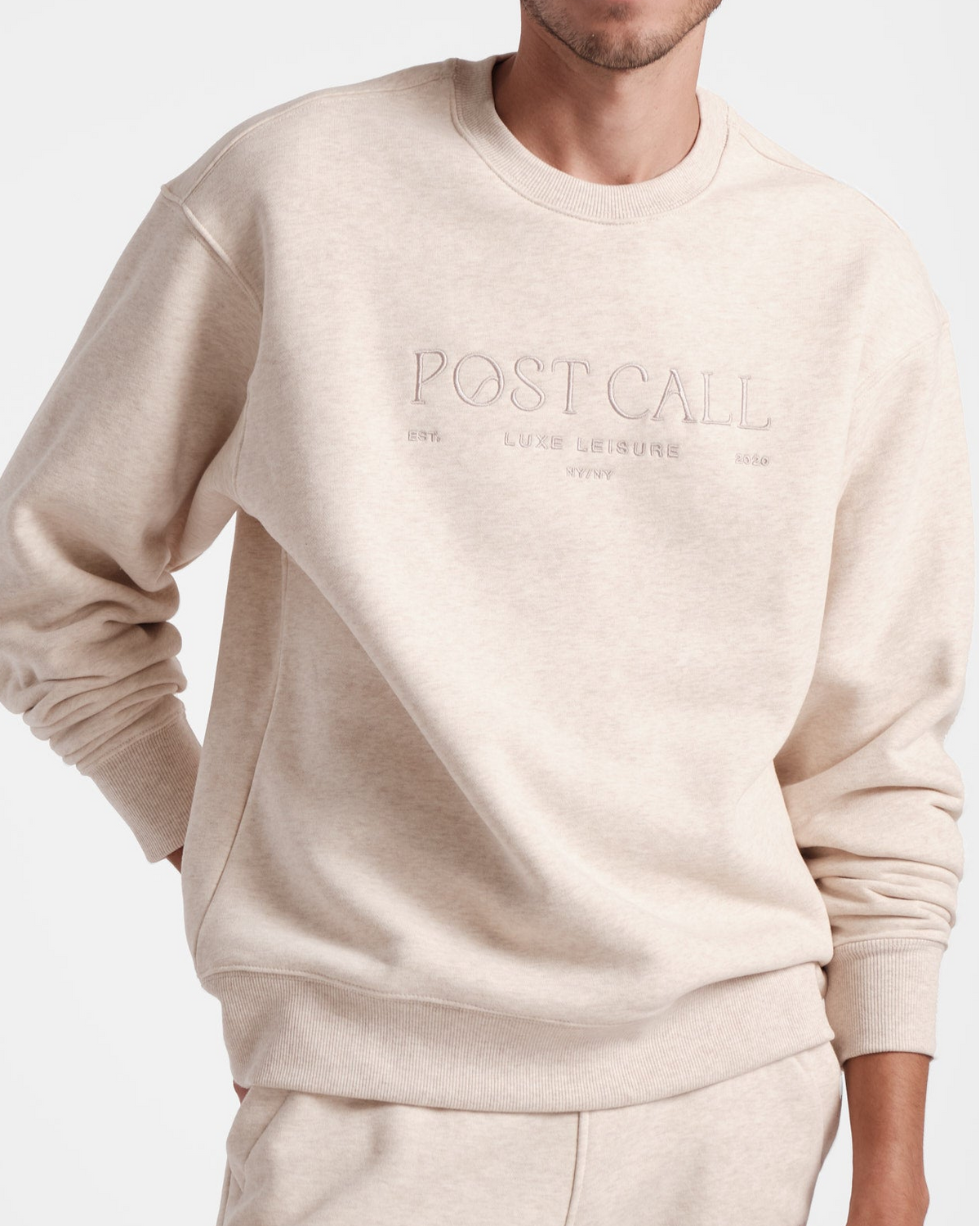 Beige sweatshirt with 'POSTCALL' branding on a white background