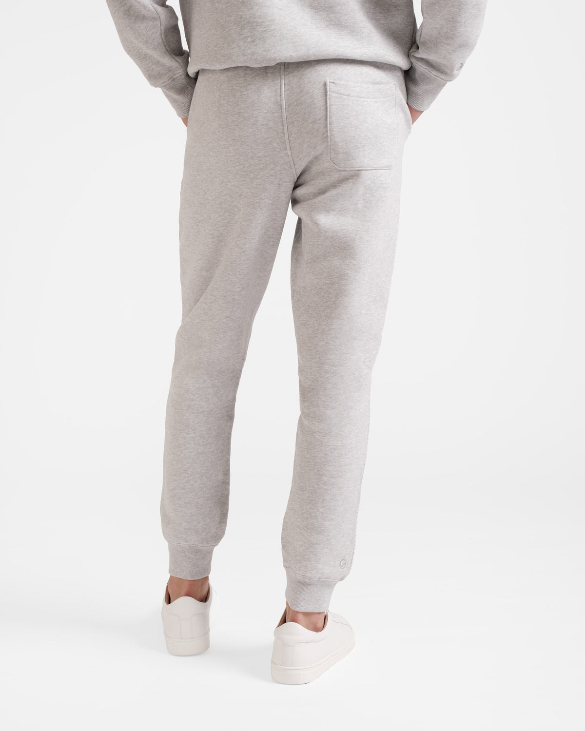 Back side view of man wearing heather grey jogger sweatpants with stretch ankle cuffs and back pocket.