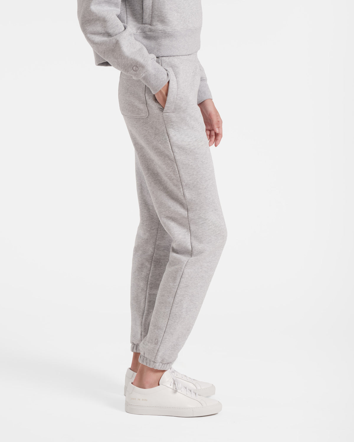 Side view of heather beige women's jogger sweatpants with model's hand in the side pocket.