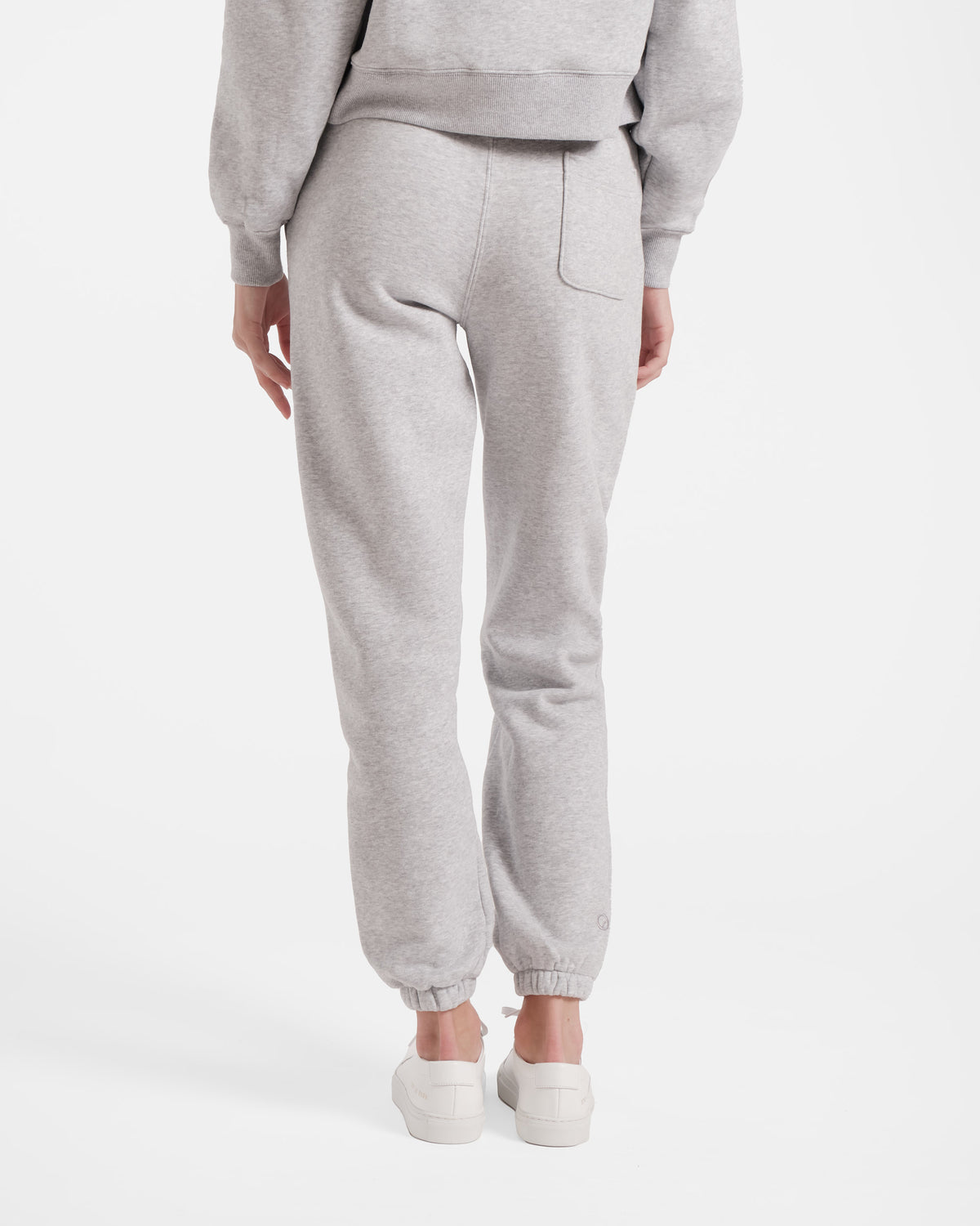 Back side view of woman wearing heather grey jogger sweatpants with a back pocket on the right side.