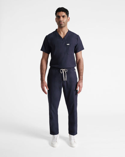 Full body shot of navy straight leg men's scrub pant with pockets