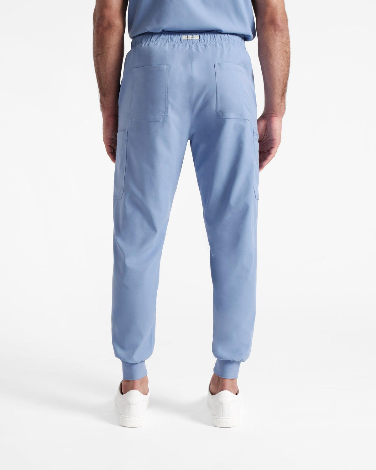Back side view of man in light blue jogger cargo scrubs with two back pockets. 